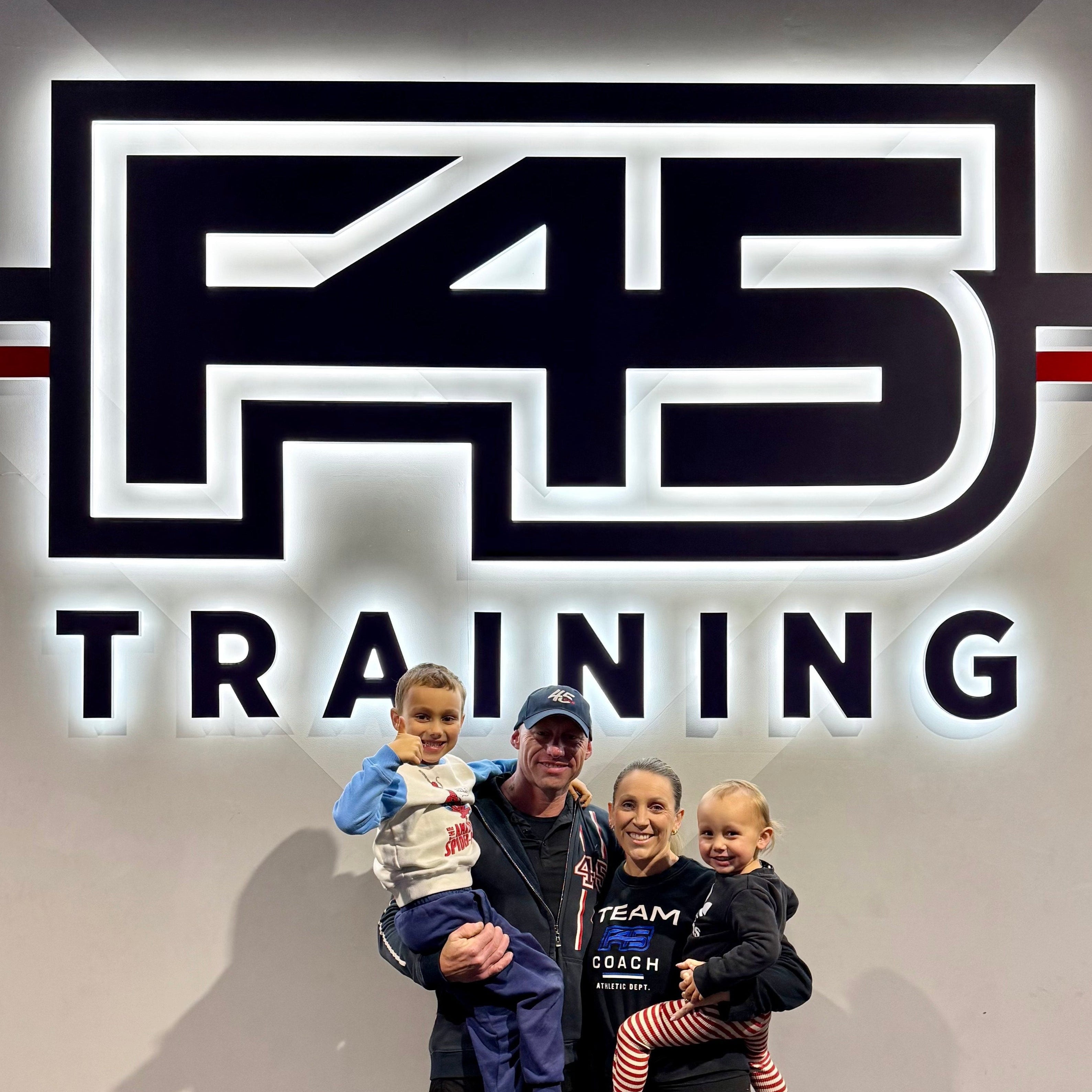 Family posing in front of an F45 Training sign